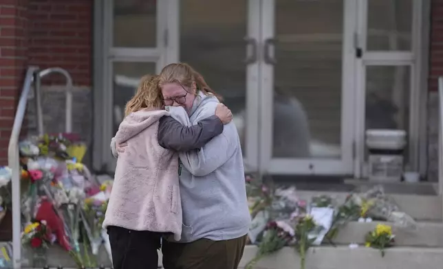 FILE - Leah Fauth gets a hug after leaving flowers in front of the West York Police Department after a police officer was killed responding to a shooting at UPMC Memorial Hospital in York, Pa., Feb. 22, 2025. (AP Photo/Matt Rourke, File)