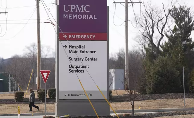 FILE - A person walks by the entrance of UPMC Memorial Hospital in York, Pa., Feb. 22, 2025. (AP Photo/Matt Rourke, File)