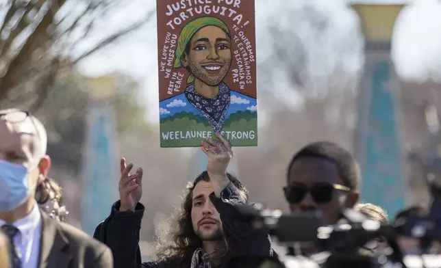 FILE - Noah Gringi holds a sign at a press conference for Manuel Esteban Paez Terán in Decatur, Ga., Feb. 6, 2023. (Arvin Temkar/Atlanta Journal-Constitution via AP, File)