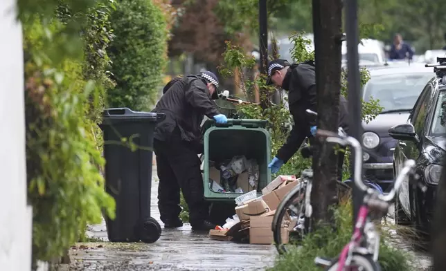 Police officers search a bin in Kentish Town, near British Prime Minister Keir Starmer's house in north London, Monday, May 12, 2025. (James Manning/PA via AP)