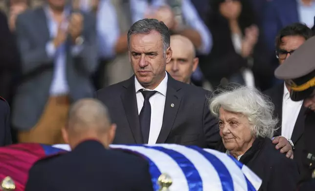 Uruguayan President Yamandu Orsi, left, stands with Lucia Topolansky, widow of the late, former President Jose Mujica, next to his casket at the presidential palace in Montevideo, Uruguay, Wednesday, May 14, 2025. (AP Photo/Matilde Campodonico)