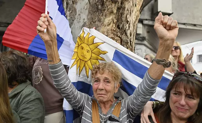 Mourners watch the casket of Uruguay's former President Jose Mujica from the sidelines of his funeral procession from the presidential palace to the National Assembly in Montevideo, Uruguay, Wednesday, May 14, 2025. (AP Photo/Santiago Mazzarovich)
