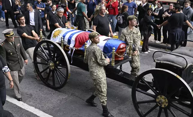 The casket of late former President Jose Mujica is transported during his funeral procession from the presidential palace to the National Assembly in Montevideo, Uruguay, Wednesday, May 14, 2025. (AP Photo/Santiago Mazzarovich)