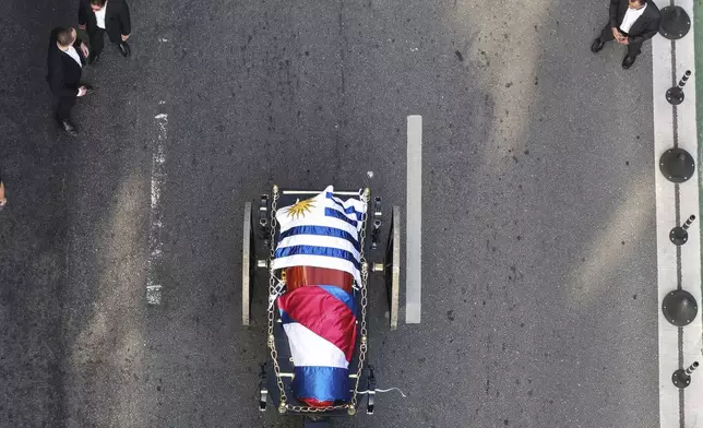 The casket of late former President Jose Mujica is transported from the presidential palace to the National Assembly during a funeral procession in Montevideo, Uruguay, Wednesday, May 14, 2025. (AP Photo/Santiago Mazzarovich)