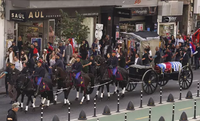 The casket of late former President Jose Mujica is transported during a funeral procession from the presidential palace to the National Assembly in Montevideo, Uruguay, Wednesday, May 14, 2025. (AP Photo/Matilde Campodonico)