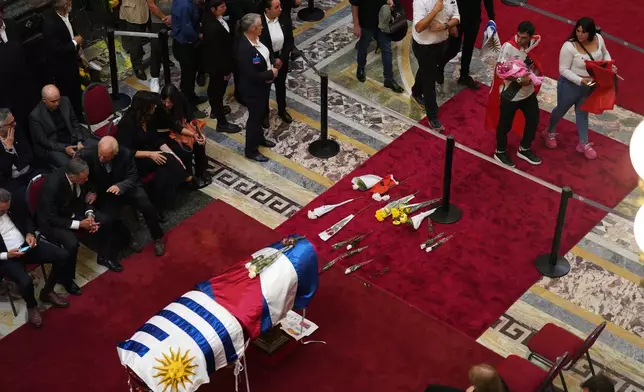 Mourners pay their final respects to the late former President Jose Mujica lying in state at the Legislative Palace in Montevideo, Uruguay, Wednesday, May 14, 2025. (AP Photo/Matilde Campodonico)