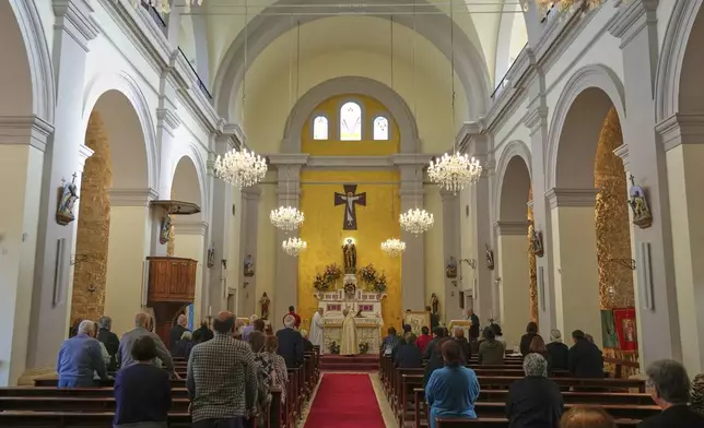 Maronite Catholic faithful attend a service on the Feast Day of St. George in St. George Church in the Maronite village of Kormakitis in the breakaway north of the ethnically divided Cyprus on Wednesday, April 23, 2025. (AP Photo/Petros Karadjias)