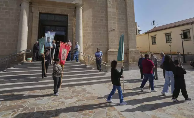 Worshippers follow a traditional procession on the Feast Day of St. George outside St. George Church in the Maronite village of Kormakitis in the breakaway north of the ethnically divided Cyprus on Wednesday, April 23, 2025. (AP Photo/Petros Karadjias)