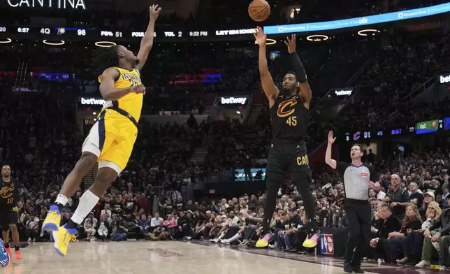 Cleveland Cavaliers guard Donovan Mitchell, right, shoots as Indiana Pacers forward Aaron Nesmith defends during the second half in Game 5 of an Eastern Conference semifinal NBA basketball playoff Tuesday, May 13, 2025, in Cleveland. (AP Photo/Sue Ogrocki)