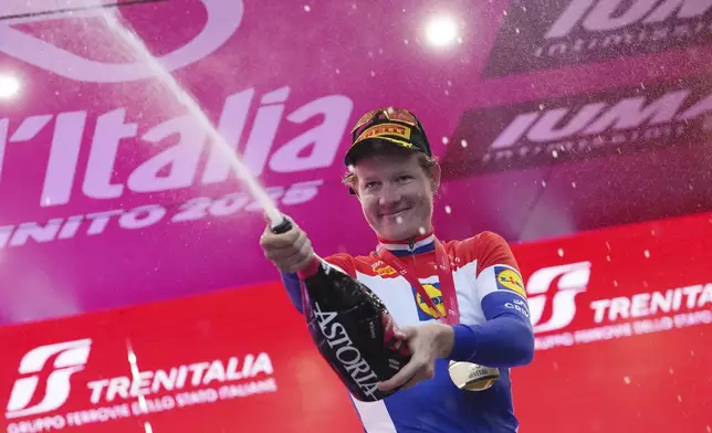 Dutch rider Daan Hoole of Lidl-Trek celebrates on the podium after winning the 10th stage of the Giro d'Italia cycling race, an individual time trial from Lucca to Pisa, Italy, Tuesday, May 20, 2025. (Gian Mattia D'Alberto/LaPresse via AP)