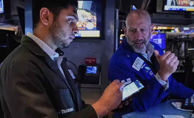 Trader Nial Pawa, left, and specialist Meric Greenbaum work on the floor of the New York Stock Exchange, Tuesday, May 6, 2025. (AP Photo/Richard Drew)