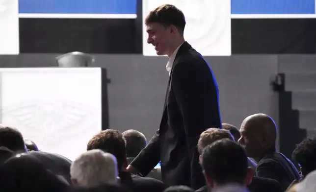 Duke's Cooper Flagg walks back to his seat after he was interviewed by ESPN after the Dallas Mavericks won the first pick in the NBA basketball draft lottery in Chicago, Monday, May 12, 2025. (AP Photo/Nam Y. Huh)