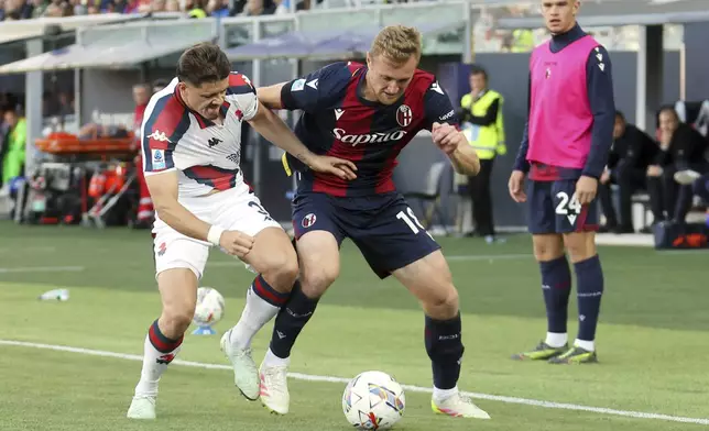 Genoa's Vitor Manuel Carvalho Oliveira "Vitinha", left, fights for the ball with Bologna's Tommaso Pobega during the Serie A soccer match between Bologna and Genoa, at the Renato Dall'Ara Stadium, in Bologna, Italy, Saturday, May 24, 2025. (Michele Nucci/LaPresse via AP)