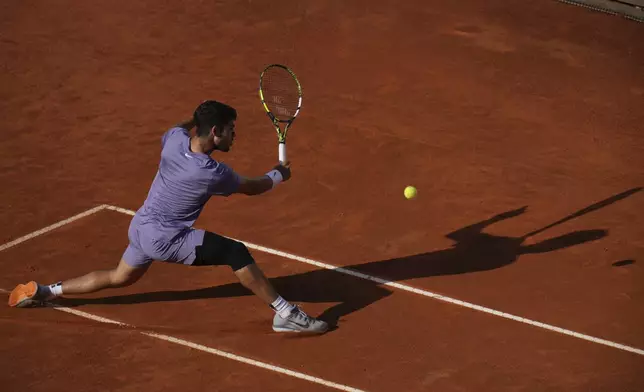Carlos Alcaraz of Spain, returns to Jannik Sinner of Italy during their final tennis match in the Italian Open at the Foro Italico in Rome, Sunday, May 18, 2025. (AP Photo/Andrew Medichini)