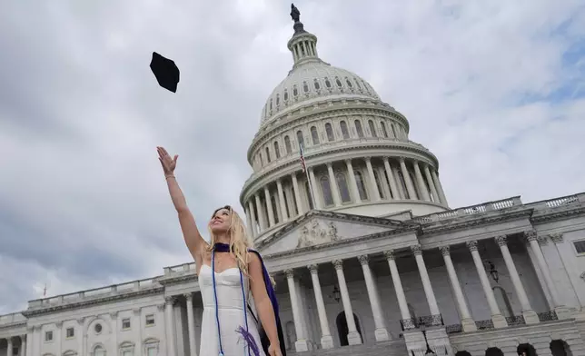 Georgetown Law student Sydnie Leigh throws her cap in the air while taking graduation photos in front of the U.S. Capitol, Thursday, May 8, 2025, in Washington. (AP Photo/Julia Demaree Nikhinson)
