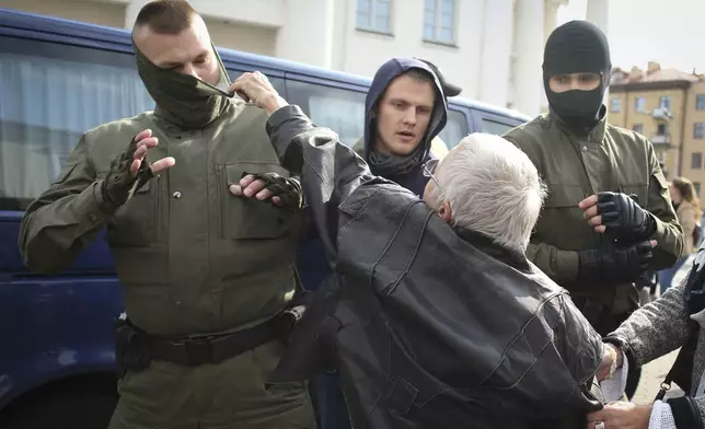 FILE - Opposition activist Nina Bahinskaya, 73, rips the mask off a police officer during an opposition rally to protest the official presidential election results in Minsk, Belarus, Saturday, Sept. 12, 2020. (Tut.by via AP, File)