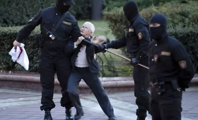 FILE - Opposition activist Nina Bahinskaya, 73, center, struggles with police during a Belarusian opposition supporters rally at Independence Square in Minsk, Belarus, Wednesday, Aug. 26, 2020. (AP Photo/Dmitri Lovetsky, File)
