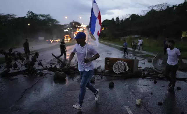 Anti-government demonstrators block a highway to protest the recently signed Panama-U.S. memorandum concerning the Panama Canal and a law that overhauls the social security agency, in Santiago, Panama, Tuesday, May 13, 2025. (AP Photo/Matias Delacroix)