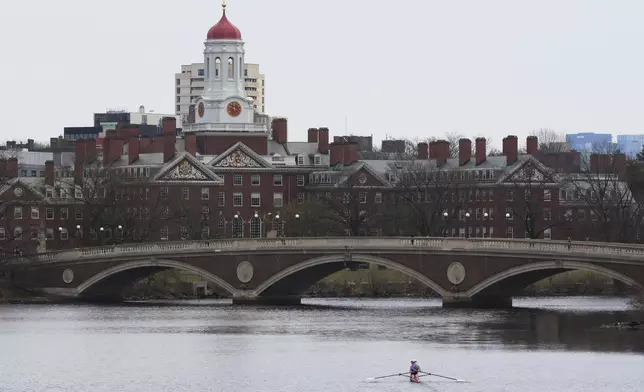 FILE - A sculler rows down the Charles River near Harvard University, at rear, April 15, 2025, in Cambridge, Mass. (AP Photo/Charles Krupa, File)