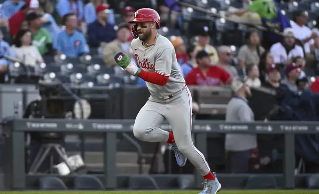 Philadelphia Phillies' Bryce Harper (3) runs home to score on a sacrifice fly in the first inning of a baseball game against the Colorado Rockies, Wednesday, May 21, 2025, in Denver. (AP Photo/Geneva Heffernan)