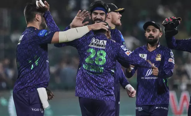Quetta Gladiators' Avishka Fernando, center, celebrates with teammates after the dismissal of Lahore Qalandars' Mohammad Naeem during the Pakistan Super League Twenty20 final cricket match between Quetta Gladiators and Lahore Qalandars, in Lahore, Pakistan, Sunday, May 25, 2025. (AP Photo/K.M. Chaudary)