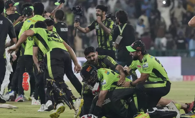 Lahore Qalandars' Sikandar Raza, center bottom, celebrates with teammates after winning the Pakistan Super League Twenty20 final cricket match against Quetta Gladiators, in Lahore, Pakistan, Sunday, May 25, 2025. (AP Photo/K.M. Chaudary)