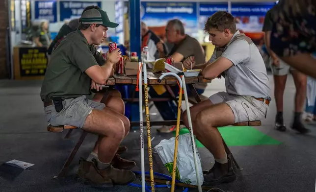 Farmers sit for lunch at the Nampo agricultural fair, one of the largest in the southern hemisphere, near Bothaville, South Africa, May 15, 2025. (AP Photo/Jerome Delay)