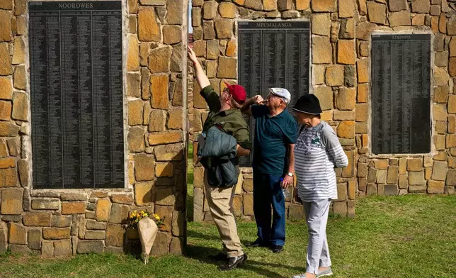 Visitors at the Nampo agricultural fair, one of the largest in the southern hemisphere, check names on the wall of remembrance, a tribute to farmers killed since 1961, near Bothaville, South Africa, May 15, 2025. (AP Photo/Jerome Delay)