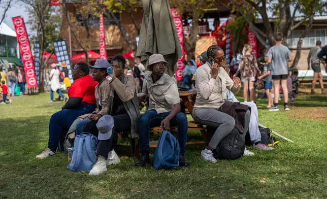 Visitors at the Nampo agricultural fair, one of the largest in the southern hemisphere, sit in there shade near Bothaville, South Africa, May 15, 2025. (AP Photo/Jerome Delay)