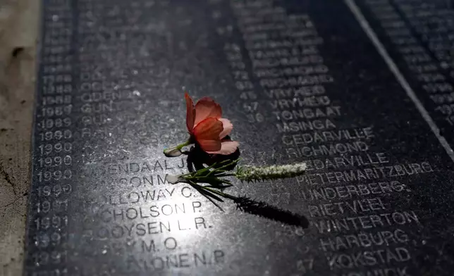A rose is set on Visitors at the Nampo agricultural fair, one of the largest in the southern hemisphere, walk past the wall of remembrance, a tribute to farmers killed since 1961, at the Nampo agricultural fair, one of the largest in the southern hemisphere, near Bothaville, South Africa, May 15, 2025. (AP Photo/Jerome Delay)