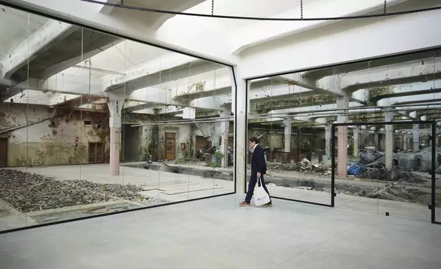 A visitor looks around the Museum of Survivors, located in a factory where Oskar Schindler saved some 1200 Jews during WWII, in Brnenec, Czech Republic, Saturday, May 10, 2025. (AP Photo/Petr David Josek)