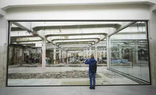 A visitor takes a photo at the Museum of Survivors, located in a factory where Oskar Schindler saved some 1200 Jews during WWII, in Brnenec, Czech Republic, Saturday, May 10, 2025. (AP Photo/Petr David Josek)