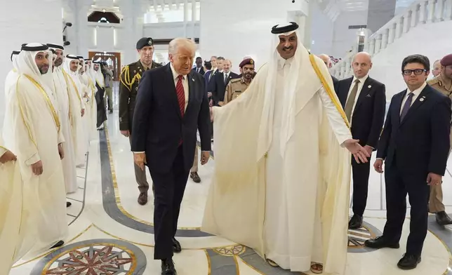 Qatar's Emir Sheikh Tamim bin Hamad Al Thani welcomes President Donald Trump during an official welcoming ceremony at the Amiri Diwan in Doha, Qatar, Wednesday, May 14, 2025. (AP Photo/Alex Brandon)