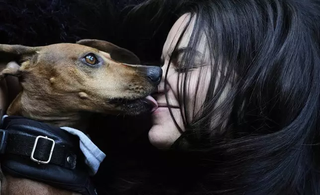 Magalí Maisonnave poses for a photo with her six-year-old dachshund Sandro, in Buenos Aires, Argentina, Sunday, April 6, 2025. (AP Photo/Natacha Pisarenko)