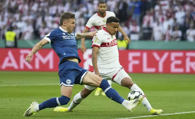 Arminia Bielefeld's Joel Grodowski , left, challenges for the ball with Stuttgart's luca Jaquez during the German soccer cup, DFB Pokal, final match between Arminia Bielefeld and VfB Stuttgart at Olympiastadion in Berlin, Germany, Saturday, May 24, 2025. (AP Photo/Matthias Schrader)