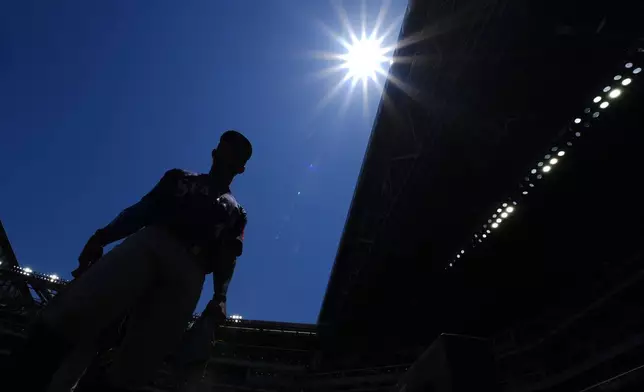 Seattle Mariners outfielder Julio Rodríguez heads to the dugout after warming up prior to a baseball game against the Texas Rangers Sunday, May 4, 2025, in Arlington, Texas. (AP Photo/Julio Cortez)
