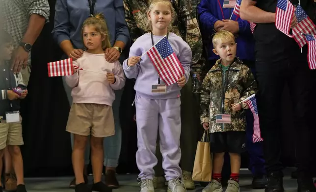 Young Afrikaner refugees from South Africa holding American flags arrive, Monday, May 12, 2025, at Dulles International Airport in Dulles, Va. (AP Photo/Julia Demaree Nikhinson)