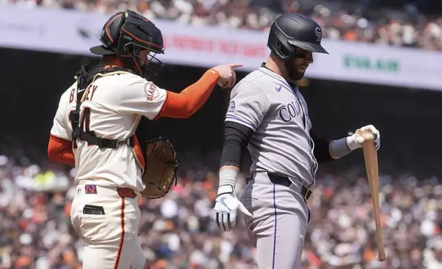 San Francisco Giants catcher Patrick Bailey, left, gestures after Colorado Rockies' Nick Martini, right, struck out during the sixth inning of a baseball game in San Francisco, Saturday, May 3, 2025. (AP Photo/Jeff Chiu)