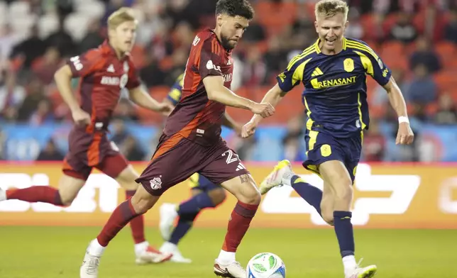 Toronto FC's Jonathan Osorio, front left, prepares to score as Nashville SC forward Sam Surridge, right, closes in during second-half MLS soccer match action in Toronto, Saturday, May 24, 2025. (Chris Young/The Canadian Press via AP)