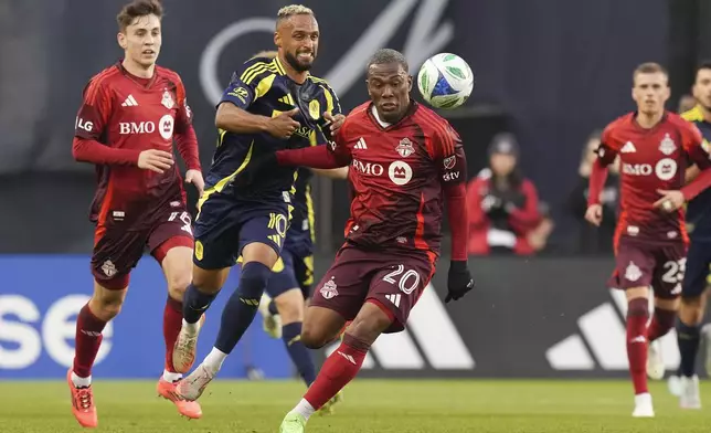 Nashville SC's Hany Mukhtar (10) competes for the ball with Toronto FC's Deybi Flores (20) during first-half MLS soccer match action in Toronto, Saturday, May 24, 2025. (Chris Young/The Canadian Press via AP)