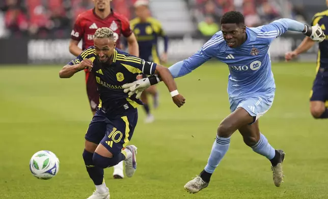 Toronto FC goalkeeper Sean Johnson (1) battles for the ball with Nashville SC's Hany Mukhtar (10) after getting caught outside his area during first-half MLS soccer match action in Toronto, Saturday, May 24, 2025. (Chris Young/The Canadian Press via AP)