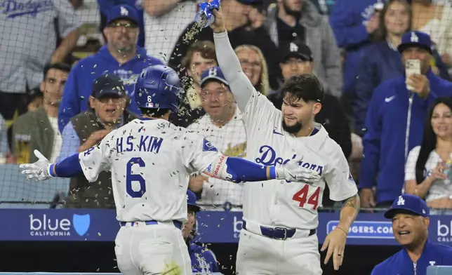 Los Angeles Dodgers' Hyeseong Kim (6) and Andy Pages (44) celebrate Kim's solo home run as manager Dave Roberts, bottom right, looks on in the fifth inning of a baseball game against the Oakland Athletics, Wednesday, May 14, 2025, in Los Angeles. (AP Photo/Jayne Kamin-Oncea)