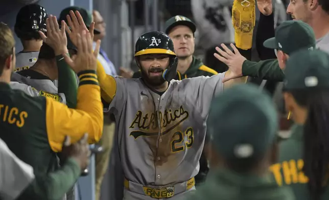 Oakland Athletics' Shea Langeliers (23) celebrates in the dugout after scoring on a Miguel Andujar double in the fourth inning of a baseball game against the Los Angeles Dodgers, Wednesday, May 14, 2025, in Los Angeles. (AP Photo/Jayne Kamin-Oncea)