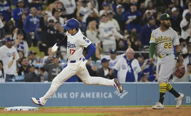 Los Angeles Dodgers' Shohei Ohtani (17) sprints home past Oakland Athletics' Miguel Andujar (22) as he and Enrique Hernández score on a double by Mookie Betts in the eighth inning of a baseball game, Wednesday, May 14, 2025, in Los Angeles. (AP Photo/Jayne Kamin-Oncea)