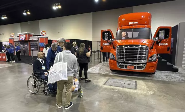 Berkshire Hathaway shareholders check out the booth for the company's Pilot truck stop chain with a photo of Warren Buffett riding in the truck on Friday, May 2, 2025 in Omaha, Neb. (AP Photo/Josh Funk)