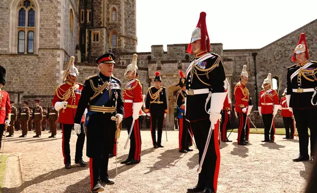 Britain's King Charles III, left, attends the presentation of the New Standards at Windsor Castle, Windsor, England, Monday May 12, 2025. (Aaron Chown/Pool via AP)