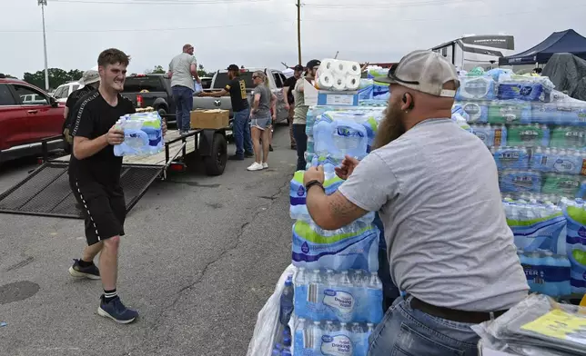Volunteers deliver water to a command center at the London-Corbin Airport in London, Ky., Monday, May 19, 2025. (AP Photo/Timothy D. Easley)