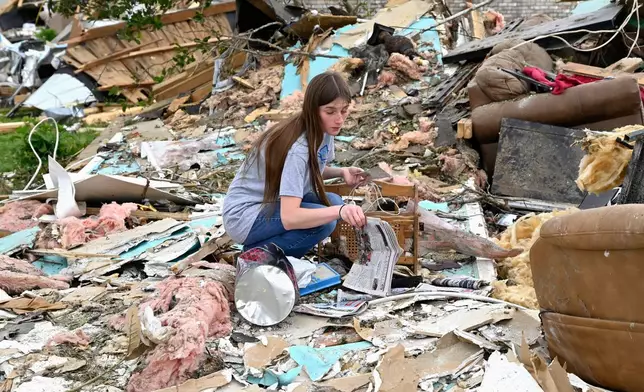 A volunteer goes through the remains of a home looking for what could be salvaged in the Sunshine Hills neighborhood in London, Ky., Monday, May 19, 2025. (AP Photo/Timothy D. Easley)