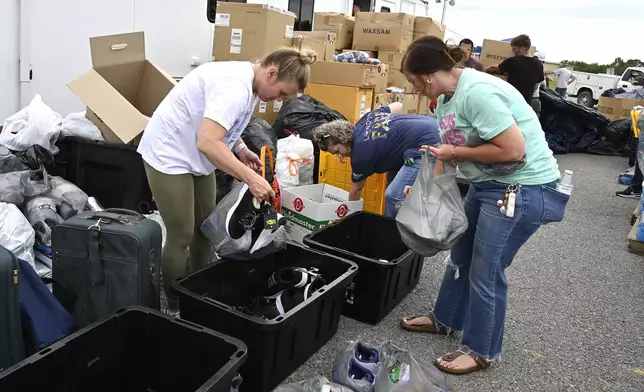 Volunteers sort clothing into bins for distribution at the command center set up at the London-Corbin Airport in London, Ky., Monday, May 19, 2025. (AP Photo/Timothy D. Easley)