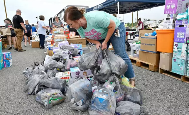 A volunteer sorts through supplies for distribution to families affected by severe storms at the London-Corbin Airport in London, Ky., Monday, May 19, 2025. (AP Photo/Timothy D. Easley)